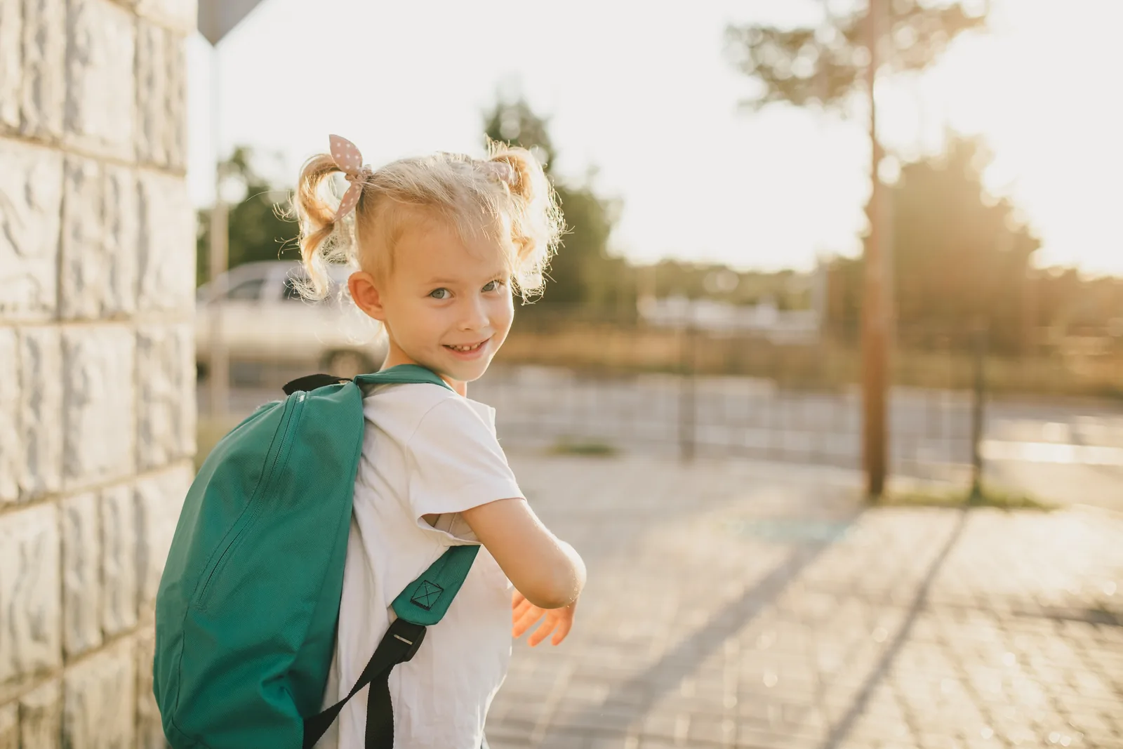 Young girl heading off to school wearing a backpack